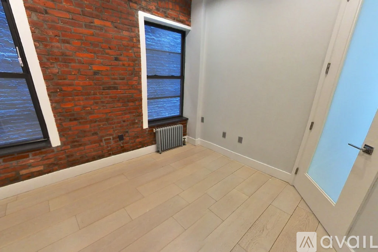 A room with a brick wall and a window.