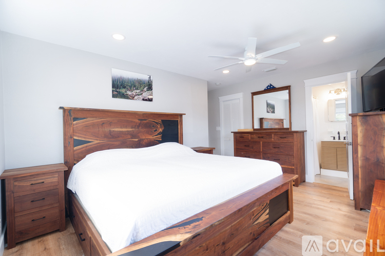 A bedroom with a large bed and wooden furniture.