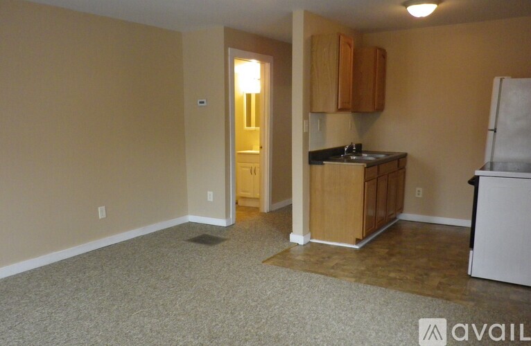A kitchen area with a refrigerator, cabinets, and a countertop.
