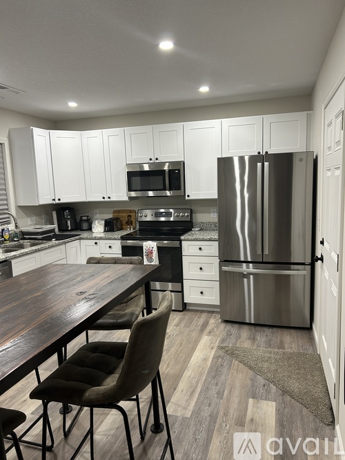 A kitchen with a wooden table and chairs.