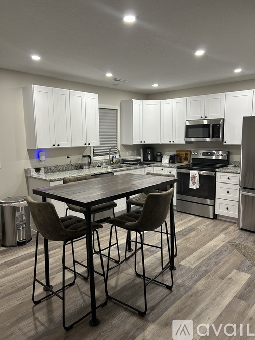 A modern kitchen with a table and chairs in the foreground.