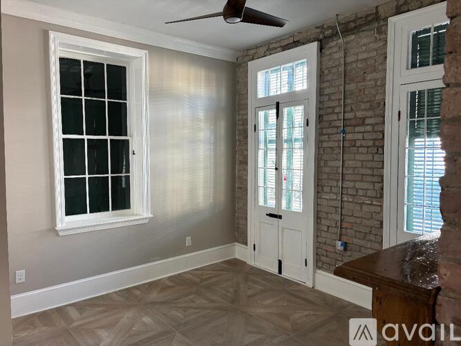 A room with a ceiling fan and a window with blinds.
