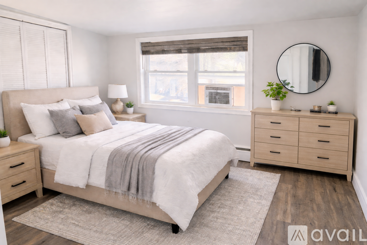 A bedroom with a large bed, nightstands, and a window.
