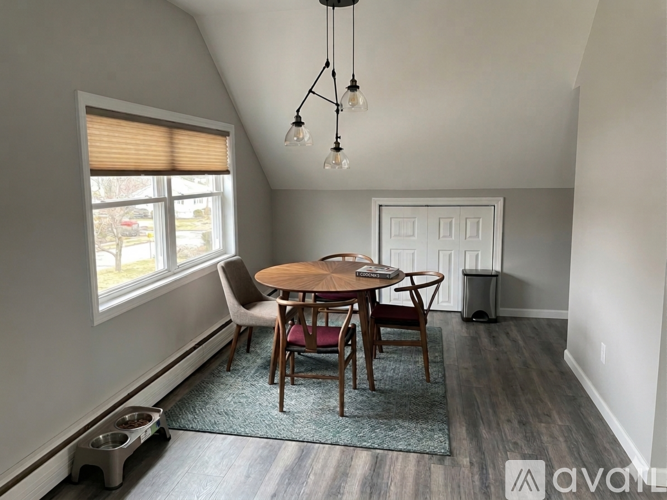 A dining room with a round table and chairs.