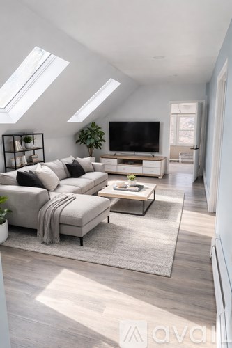 A living room with a grey sofa and a grey rug.