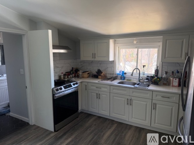 A kitchen with white cabinets and a black stove top oven.