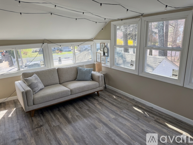 A living room with a grey couch and wooden flooring.