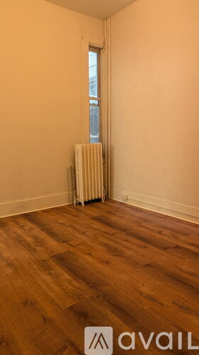 A room with a window and a radiator on the wall.