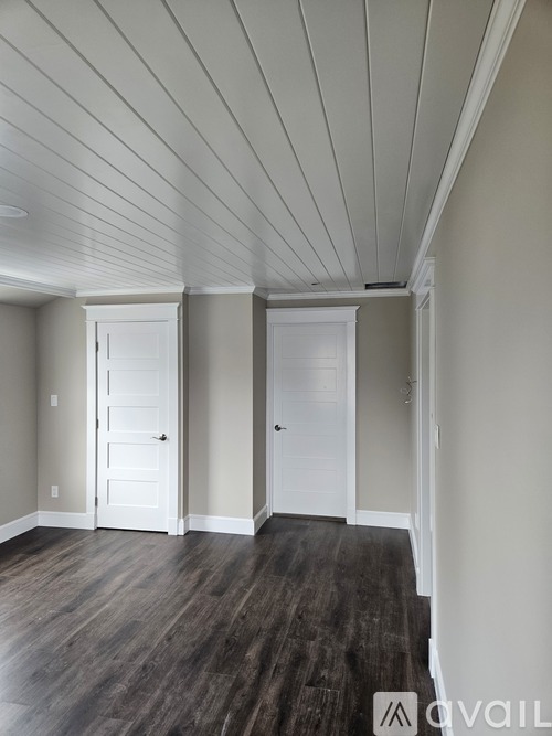 A room with a white ceiling and wooden floor.
