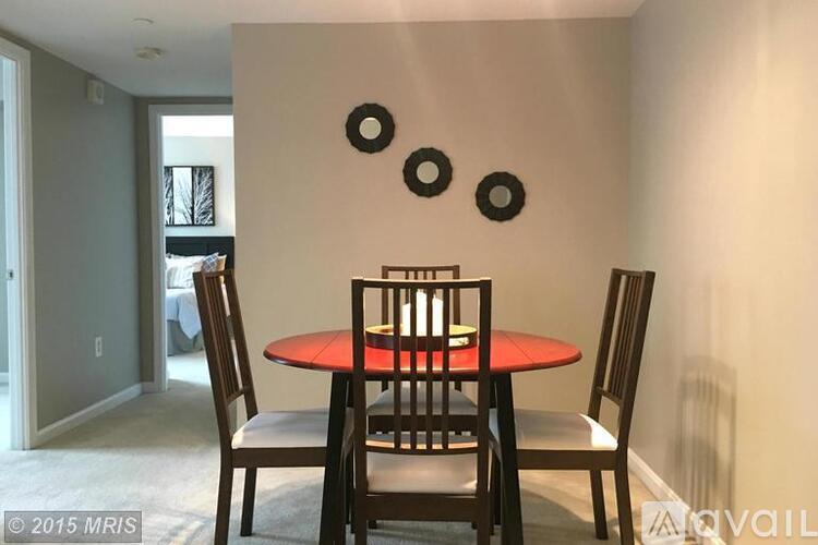 A dining room with a red table and chairs.