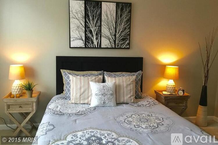 A bedroom with a large bed and two lamps on either side.