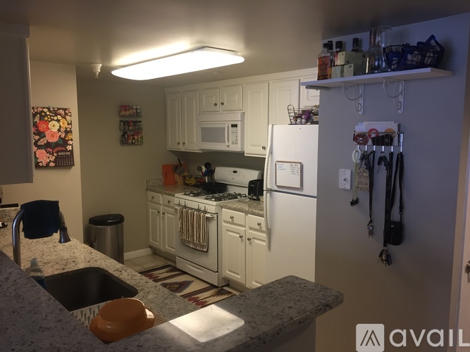 A kitchen with white cabinets and a granite countertop.