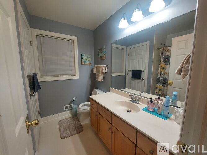 A bathroom with a toilet, sink, and mirror.