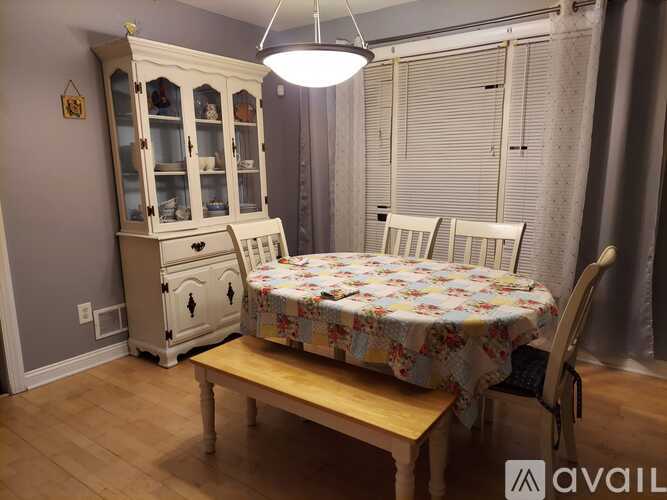 A dining room with a table, chairs and a cabinet.