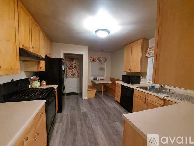 A kitchen with wooden cabinets and a black stove top oven.