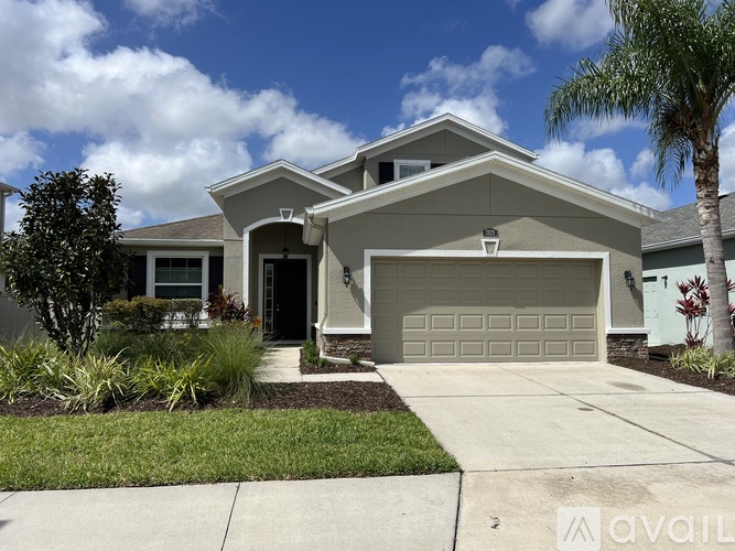 A house with a garage and a driveway in front of it.