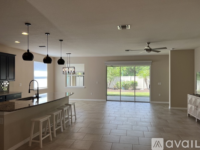 A modern kitchen with a bar area and a view of the backyard.