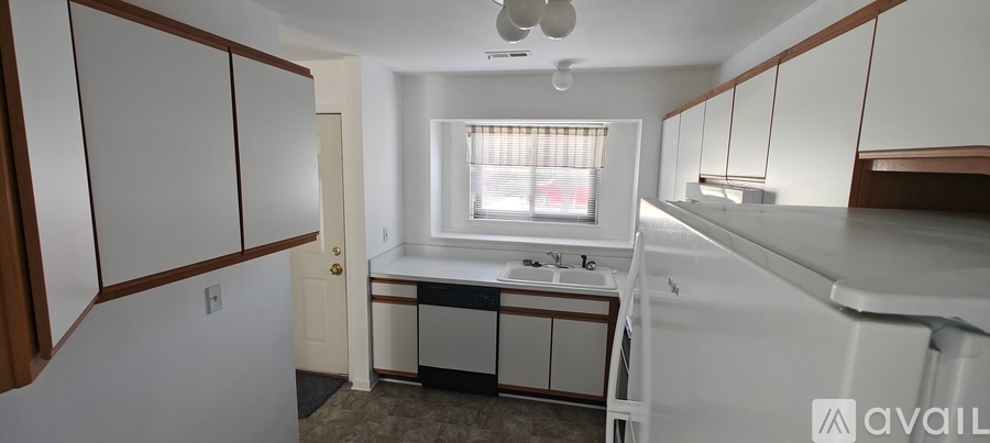 A kitchen with white cabinets and a window.