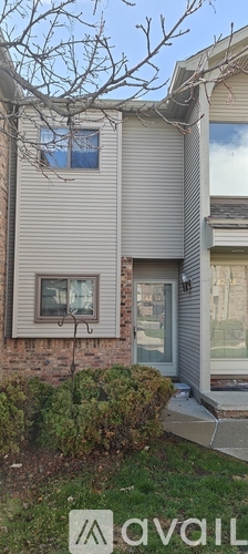 A house with a grey siding and a window with a blue frame.