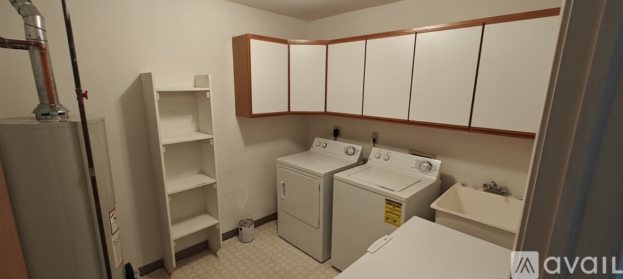 A laundry room with a washer and dryer, a sink, and a cabinet.