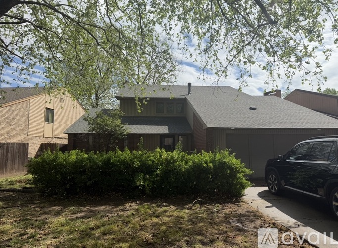 A house with a black car parked in front.