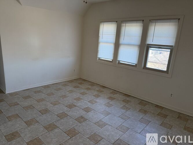 A room with a tiled floor and two windows.