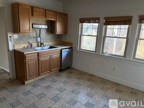 A kitchen with wooden cabinets and a checkered floor.