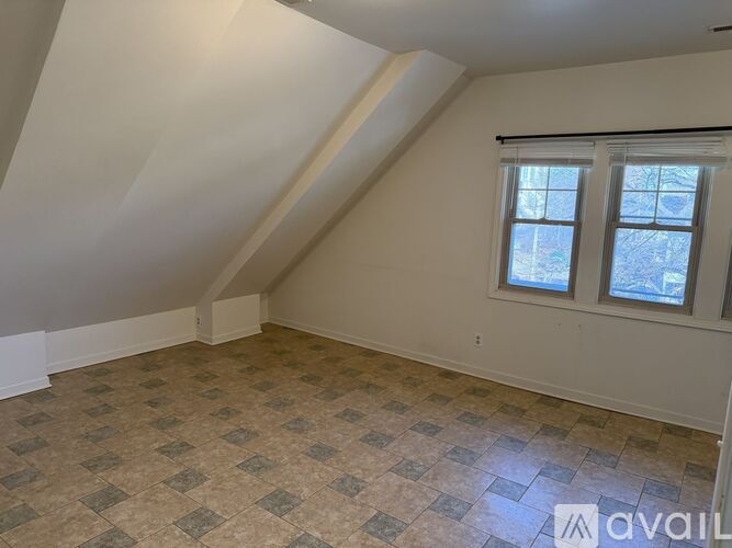 A room with a tiled floor and a window with a view of trees.
