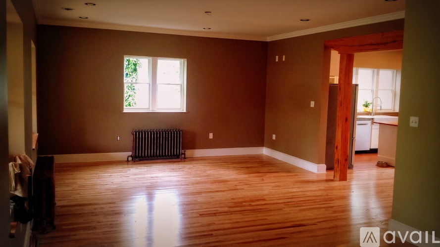 A room with brown walls and wooden floors is available for rent.