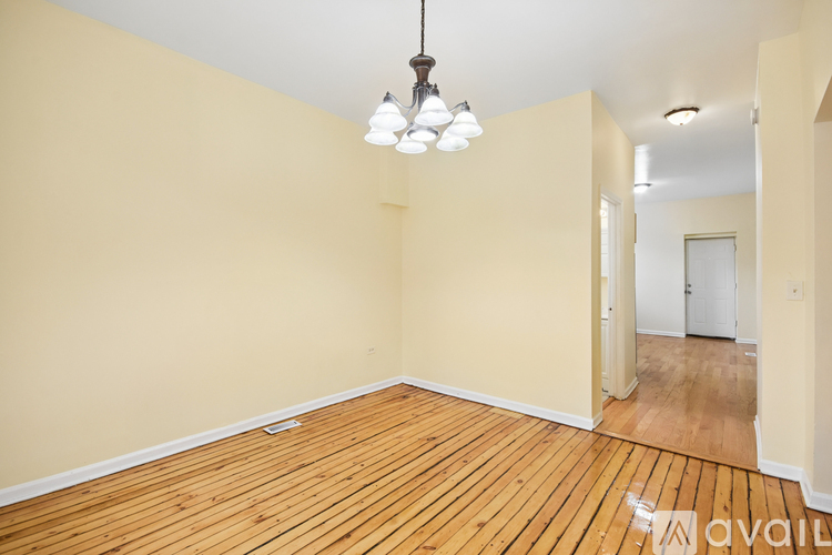 A room with wooden floors and a light fixture hanging from the ceiling.