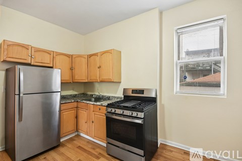 A kitchen with a stainless steel refrigerator, oven, and wooden cabinets.