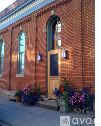 A red brick building with a wooden door and windows.
