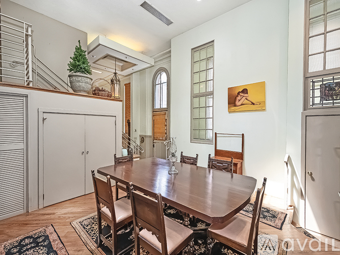 A dining room with a wooden table and chairs.