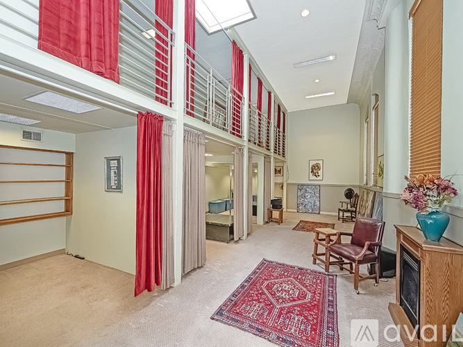 A living room with a red rug and a wooden cabinet.