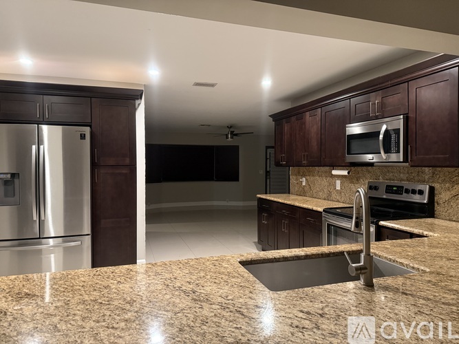 A kitchen with brown cabinets and a granite countertop.