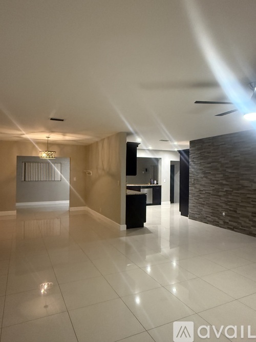 A spacious room with a tiled floor and a ceiling fan.