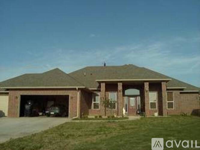 A house with a garage and a car is available for sale.