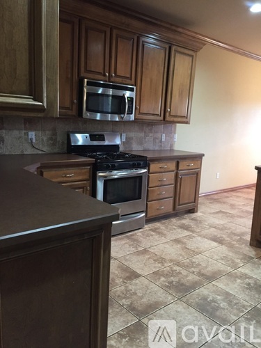 A kitchen with brown cabinets and a tile floor.