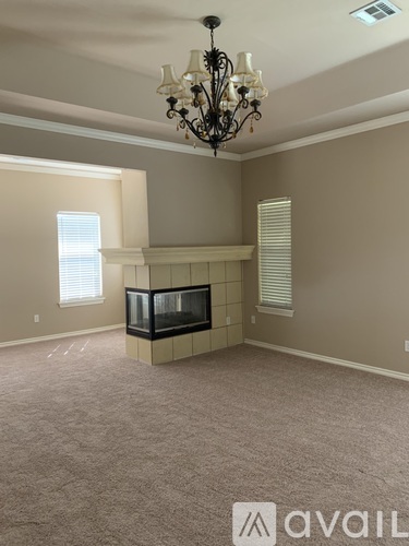 A living room with a fireplace and a chandelier.