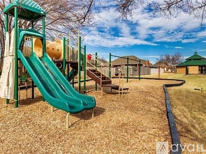 A playground with a green slide and a yellow ball.