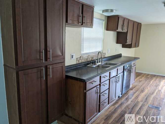 A kitchen with wooden cabinets and a black countertop.