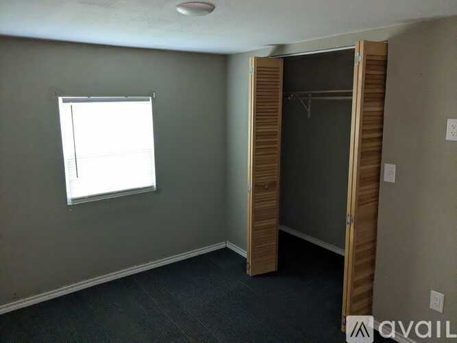 A room with a window and a closet.