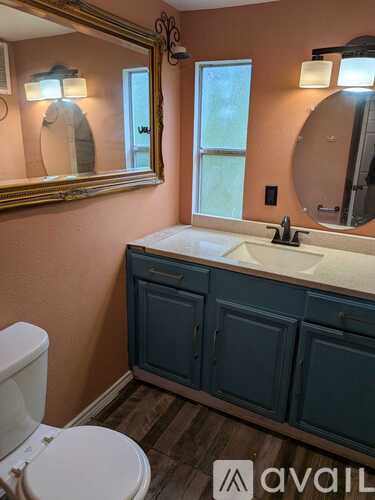 A room with a ceiling fan and wooden flooring.