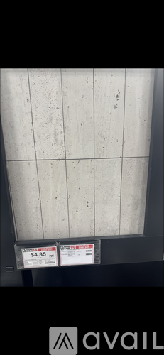 A white tiled wall with two price tags reading $4.95.