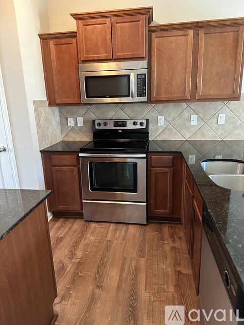 A kitchen with wooden cabinets and a stainless steel oven.