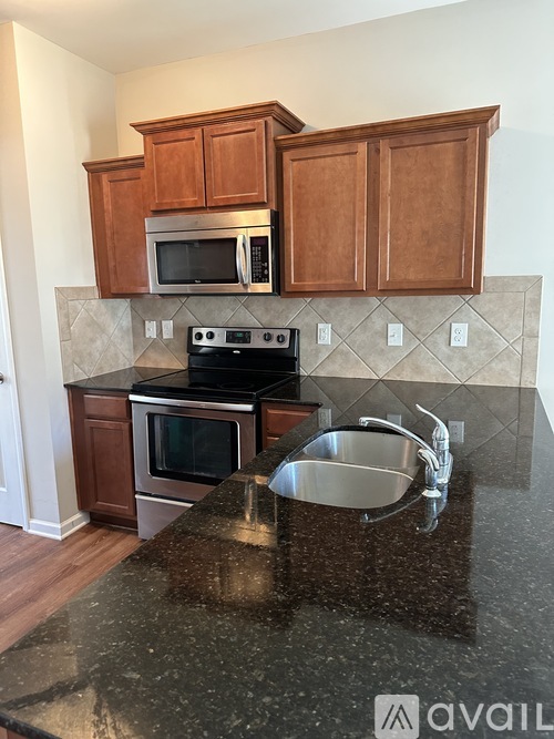 A kitchen with brown cabinets and a granite countertop.