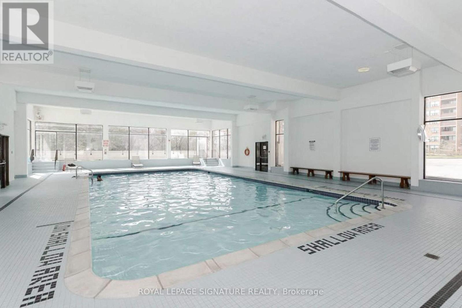 A large indoor swimming pool with the words "SHALLOW WATER" written on the bottom.