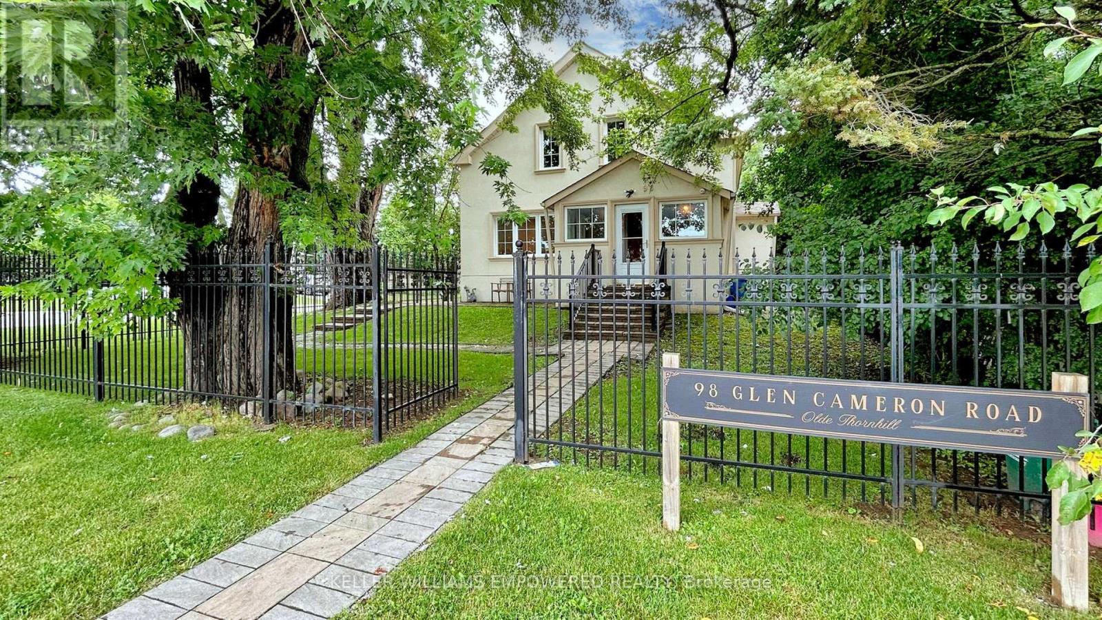 A house is behind a black fence with a sign that says 98 Glen Cameron Road.