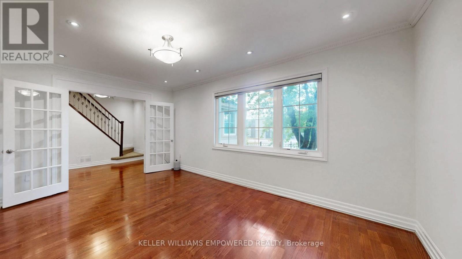 A spacious room with a staircase and a window.