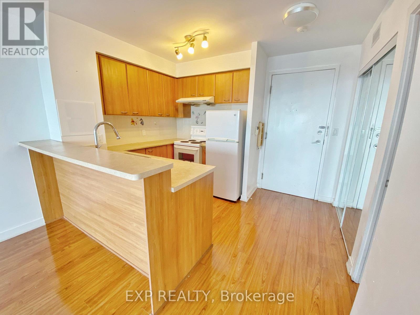 A kitchen with wooden cabinets and a white fridge.